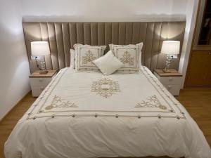 a bedroom with a white bed with two lamps at NEW SUPER LUXURY APARTMENT (CENTRAL MARRAKECH) in Marrakesh
