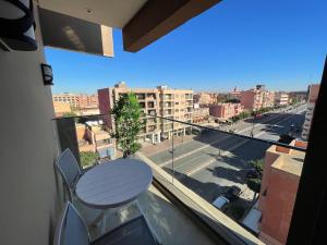 a balcony with a table and a view of a street at NEW SUPER LUXURY APARTMENT (CENTRAL MARRAKECH) in Marrakesh