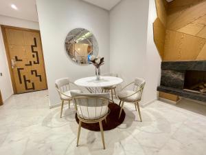 a dining room with a table and chairs and a mirror at NEW SUPER LUXURY APARTMENT (CENTRAL MARRAKECH) in Marrakesh