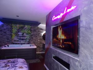 a bathroom with a fireplace and a bath tub and aburning at Loveroom 54 in Jarville-la-Malgrange