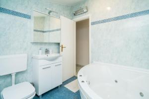 a bathroom with a white tub and a sink and a toilet at Deluxe Duplex House With Terrace in Dubrovnik