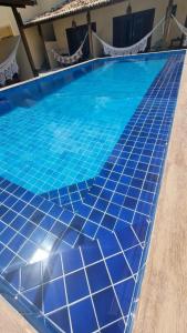 een blauw zwembad met blauwe tegels op de vloer bij Pousada Lua Nova Charmosa Pipa in Pipa