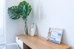 a table with a plant and a vase on it at HolidayRento Bondi Rooftop Pool & Air Con Studio in Sydney +28 photos
