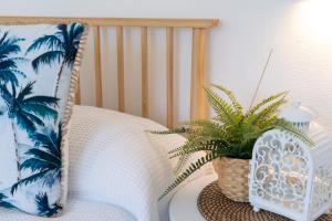 Dormitorio con cama con almohada y planta en HolidayRento Bondi Beach Ocean View Rooftop Pool en Sídney