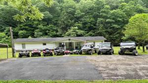 um grupo de veículos estacionados em frente a uma casa em Sheppard's Holler em Parsley