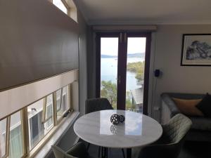 a living room with a table and a view of the ocean at Lakeside Studio in Jindabyne