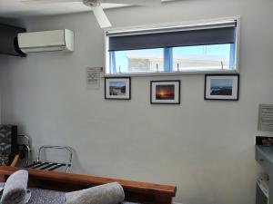 a room with a window with four pictures on the wall at Denchys B&B in Matamata