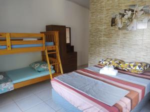 een slaapkamer met 2 stapelbedden en een ladder bij Suítes Carla e Carol in Praia de Araçatiba