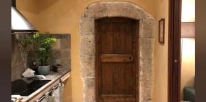 - une porte en bois dans une cuisine à côté d'un comptoir dans l'établissement PortaVecchia69, à Sutri