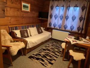 ブコビナ・タトシャンスカにあるSkalnica Pokoje Gościnneのベッドルーム1室(ベッド1台、テーブル、ソファ付)