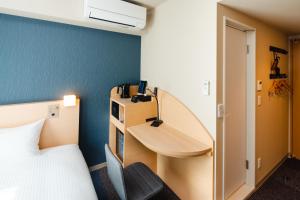 a hotel room with a bed and a desk and a bed and a desk at JRクレメントイン今治 in Imabari