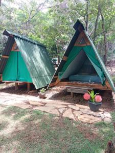 dos tiendas en una mesa de picnic en un patio en Recanto da Filó Serra do Cipó en Serra do Cipo