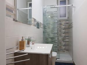a bathroom with a sink and a glass shower at Tabula House - 4 ELEMENTS in Catania