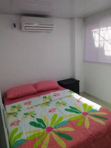 a bedroom with a bed with a colorful comforter at Apartamento en Taganga in Taganga