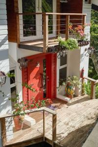 ein Haus mit einer roten Tür und ein paar Topfpflanzen in der Unterkunft Mansion Dubai-Mountain-Jacuzzi-4BR-Jamaca De Dios in Jarabacoa