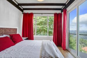a bedroom with red curtains and a large window at Mansion Dubai-Mountain-Jacuzzi-4BR-Jamaca De Dios in Jarabacoa