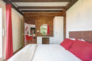 um quarto com uma grande cama branca com almofadas vermelhas em Mansion Dubai-Mountain-Jacuzzi-4BR-Jamaca De Dios em Jarabacoa