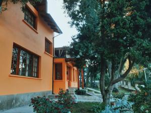 una casa naranja con un árbol delante de ella en Alojamiento Los Alelies en San Carlos de Bariloche