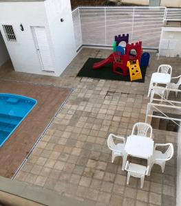 a patio with a table and chairs and a playground at Condomínio Recanto dos Dourados in Três Marias