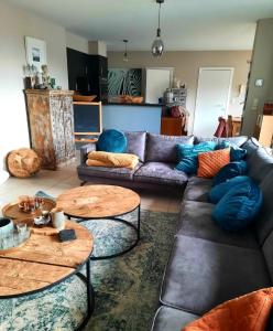 uma sala de estar com um sofá e duas mesas em loft appartement met 3 slaapkamers en gratis parking em Ichtegem