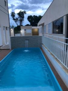 a swimming pool with a fountain on the balcony of a house at Condomínio Recanto dos Dourados - Casa de Temporada in Três Marias