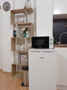 uma cozinha com um micro-ondas em cima de um frigorífico em Prague Suite em Burgas