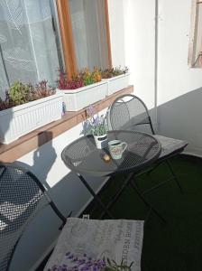 uma pequena mesa e cadeiras numa varanda com flores em Prague Suite em Burgas