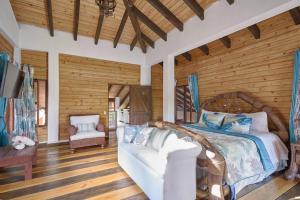 ein Schlafzimmer mit einem Bett und einem Sofa in einem Zimmer in der Unterkunft Villa ines-4X4only-Jarabacoa-View-Jacuzzi-5BR in Jarabacoa