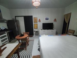 um quarto com uma cama, uma mesa e uma televisão em Tiny Home Garden Bananeiras em Bananeiras