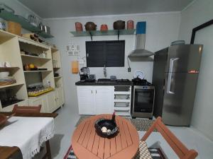 uma cozinha com um frigorífico e uma mesa em Tiny Home Garden Bananeiras em Bananeiras