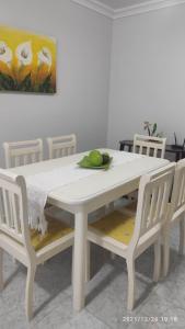 a white dining room table with two white chairs at Apartamento Beira mar in Arroio do Silva