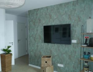 a living room with a flat screen tv on a wall at Consuls Ocean View in Ponta Delgada