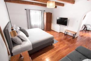 a bedroom with a bed and a tv and a couch at Bello atardecer - hotel boutique in Tequisquiapan +22 photos