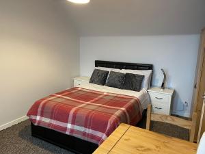 a bedroom with a bed and a table in it at Port House in Gairloch +20 photos