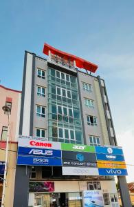 a tall building with a sign in front of it at Alexis KT Roomstay in Kuala Terengganu