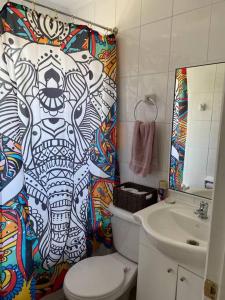 Un baño con inodoro, lavabo y cortina de ducha. en Hermosa casa a 10 minutos de Huilo Huilo, en Choshuenco