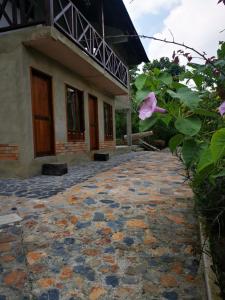 a house with a stone walkway in front of it at Hotel Boutique Albania in Otanche