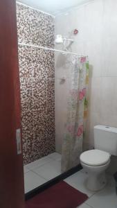 a bathroom with a shower curtain and a toilet at Hospedaria D' Gabi in São Pedro da Aldeia +97 photos