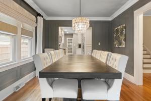 a dining room with a table and white chairs at Gorgeous Downtown Bungalow, Walk Everywhere!!! in Lake Geneva