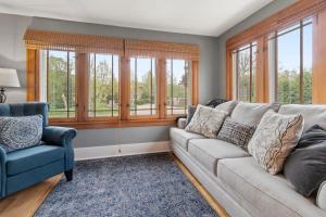 a living room with a couch and a chair and windows at Gorgeous Downtown Bungalow, Walk Everywhere!!! in Lake Geneva
