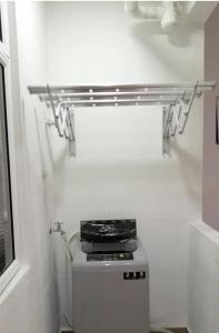 a bathroom with a shelf above a refrigerator at Cozy Studio house /Soho Unit Near Kampar Utar in Kampar