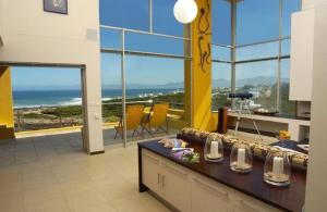 a room with a table with a view of the ocean at Crayfish Lodge Sea & Country Guest House in Gansbaai