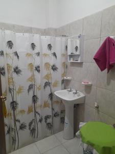 a bathroom with a shower curtain with a sink at Complejo Don Tito in San Juan