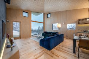 a living room with a blue couch and a table at Foxwood B by H2 Life in Niseko