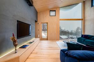 a living room with a blue couch and a tv at Foxwood B by H2 Life in Niseko