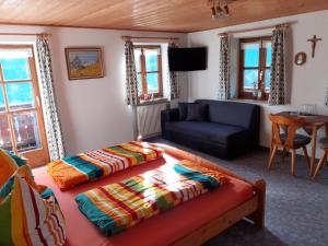 a living room with a bed and a couch at Klettnerlehen in Ramsau