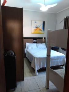 ein Schlafzimmer mit einem weißen Bett und einem großen Bett der Marke sidx sidx sidx. in der Unterkunft Edicula com um quarto banheiro e piscina e lazer in Foz do Iguaçu