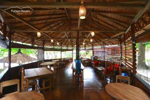 a restaurant with wooden tables and wooden chairs at Pulisan Resort in Rinondoran