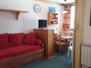 ein Wohnzimmer mit einem roten Sofa und einem Tisch in der Unterkunft Appartement Valmorel, 1 pièce, 4 personnes - FR-1-356-391 in Les Avanchers
