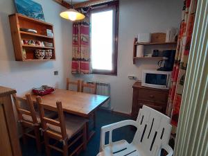 eine Küche mit einem Tisch, Stühlen und einer Mikrowelle in der Unterkunft Appartement Valmorel, 1 pièce, 4 personnes - FR-1-356-391 in Les Avanchers